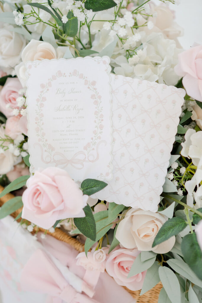 Garden Rose baby shower invitation with blush florals and delicate bow illustration.