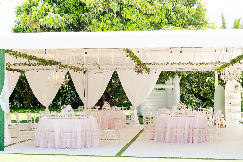 Outdoor garden venue prepared for an elegant baby shower with white tent and garden setting.